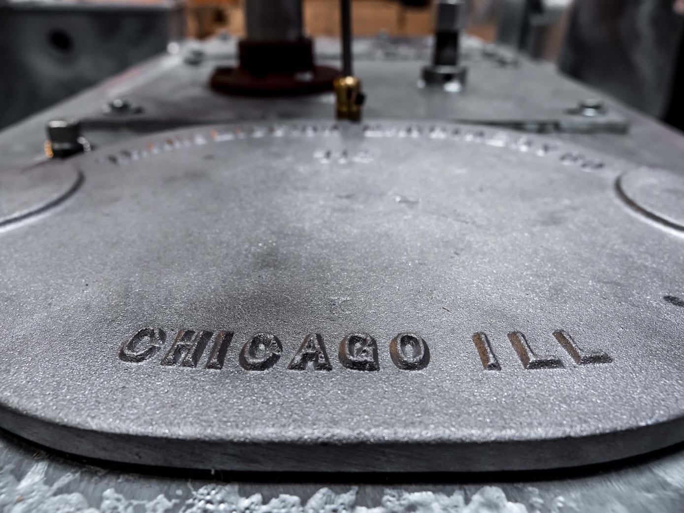 A photo of the basin lid on the Tramco flood control system with a bold CHICAGO ILL protruding from the metail.