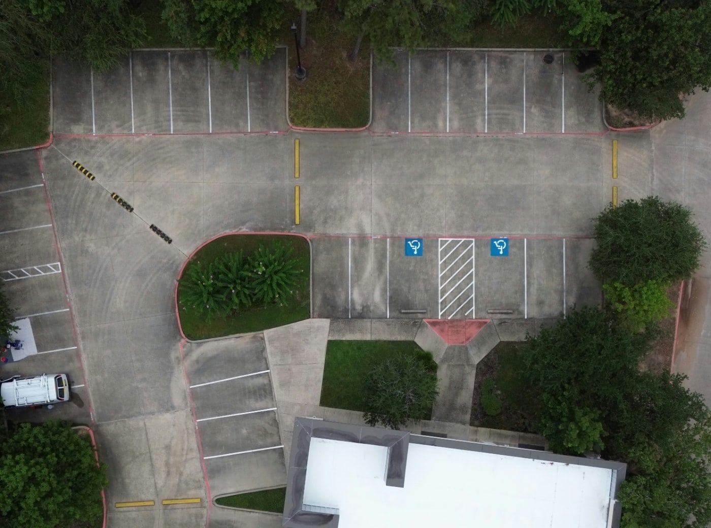 Faded parking lot markings before restriping in The Woodlands TX
