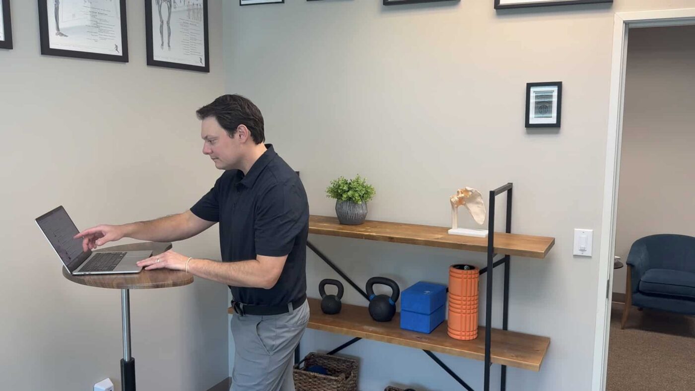 Dr. Henry reviewing a rehabilitation exercise program on a laptop.