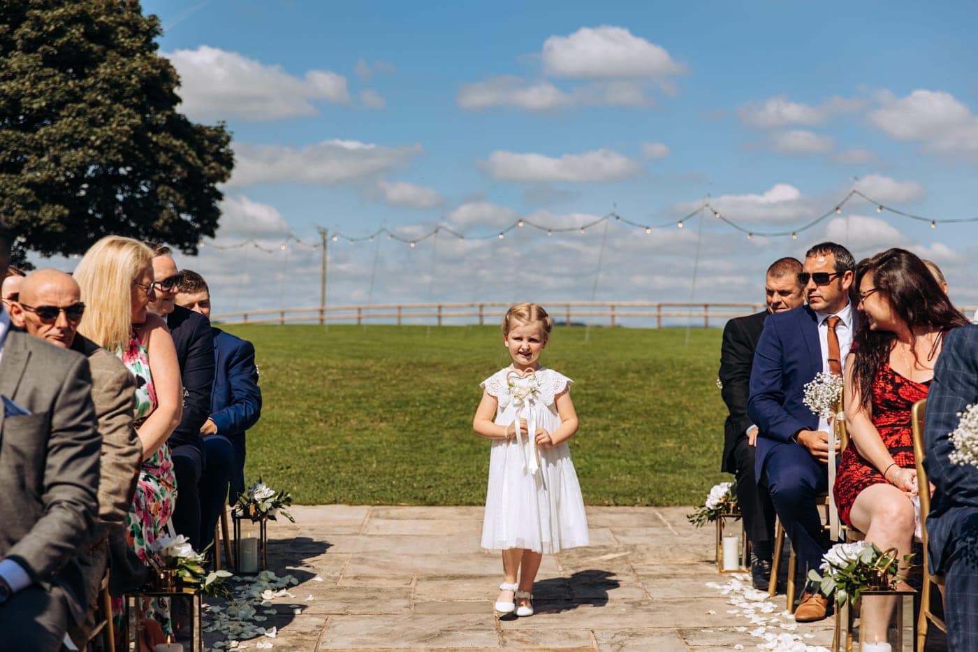 an outdoor ceremony with the bride walking down the aisle to get married at heaton house farm