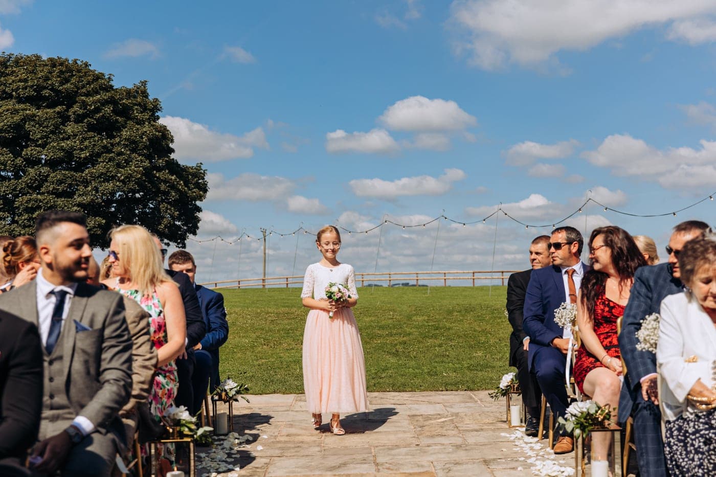 an outdoor ceremony with the bride walking down the aisle to get married at heaton house farm