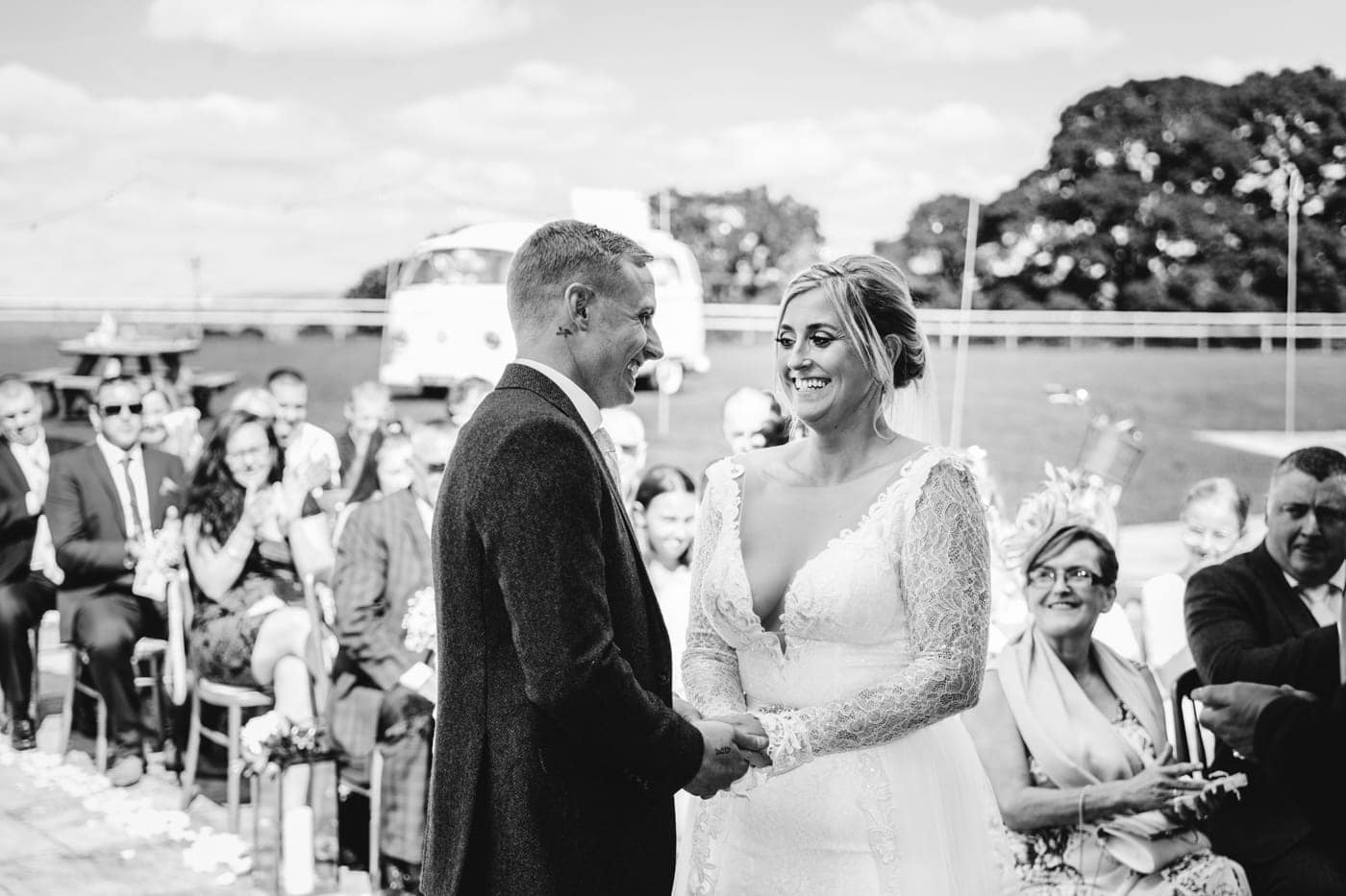 an outdoor ceremony with the bride walking down the aisle to get married at heaton house farm