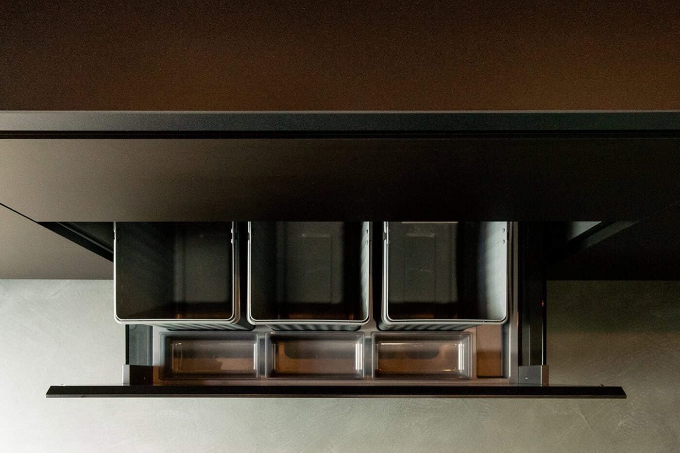 Integrated pull-out waste bin drawer with three compartment recycling sorting bins.