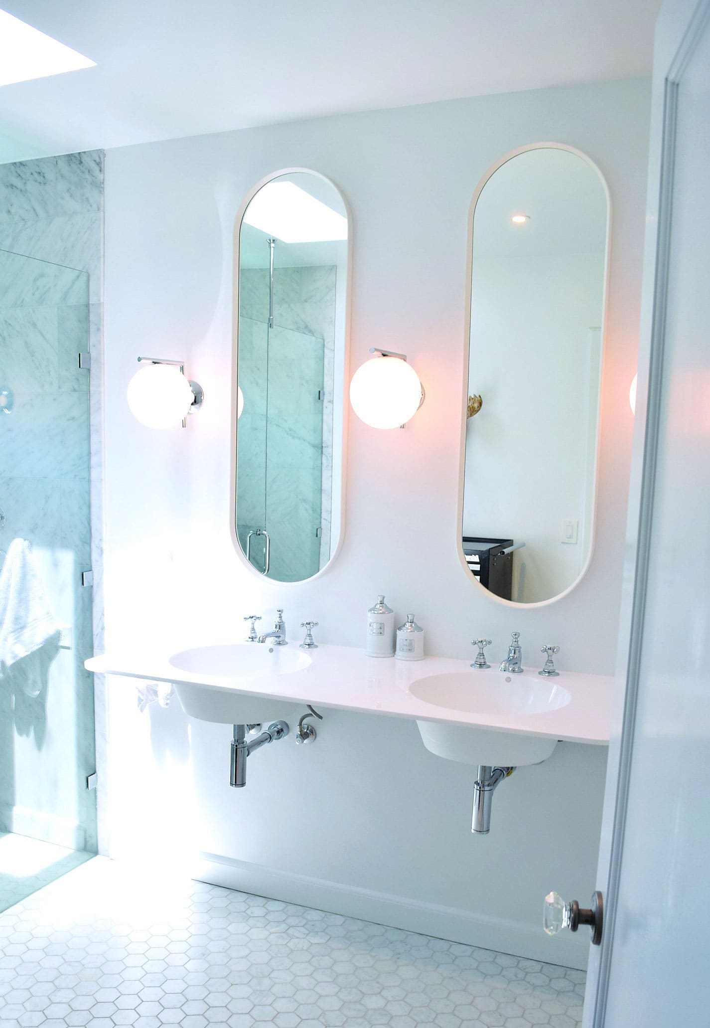 bathroom with elongated oval windows and white marble shower