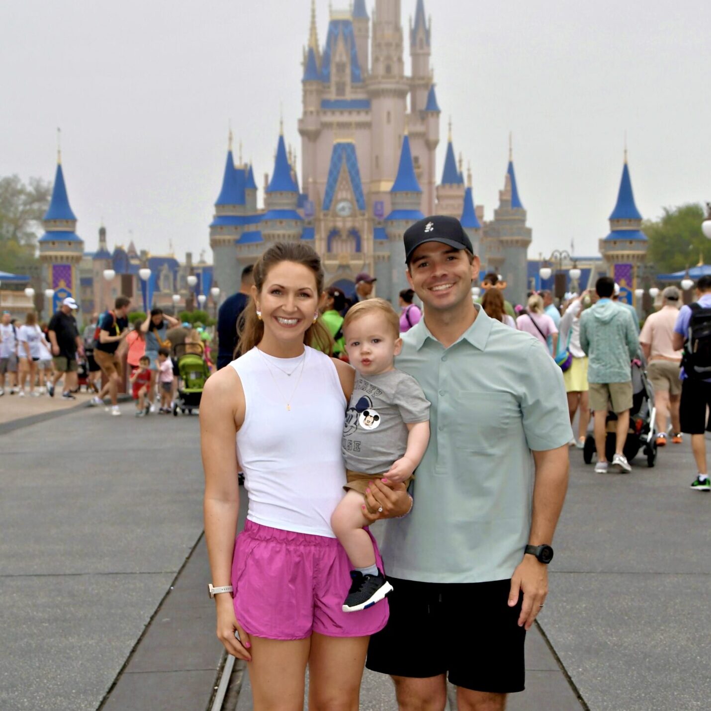 Family enjoying a Disney theme park vacation in front of Sleeping Beauty Castle.