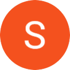 An orange circle with a white, uppercase letter "S" in the center on a light gray background.