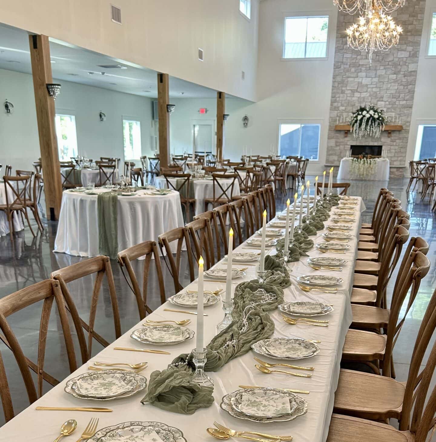 Elegant long banquet table set with fine place settings and chandelier in the reception hall