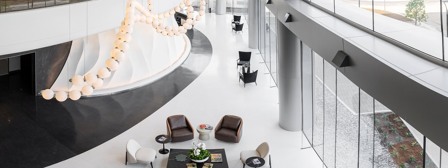 An overhead view of sleek modern office space for lease in Raleigh. Dark modern office chairs stand out against clean white finishes.
