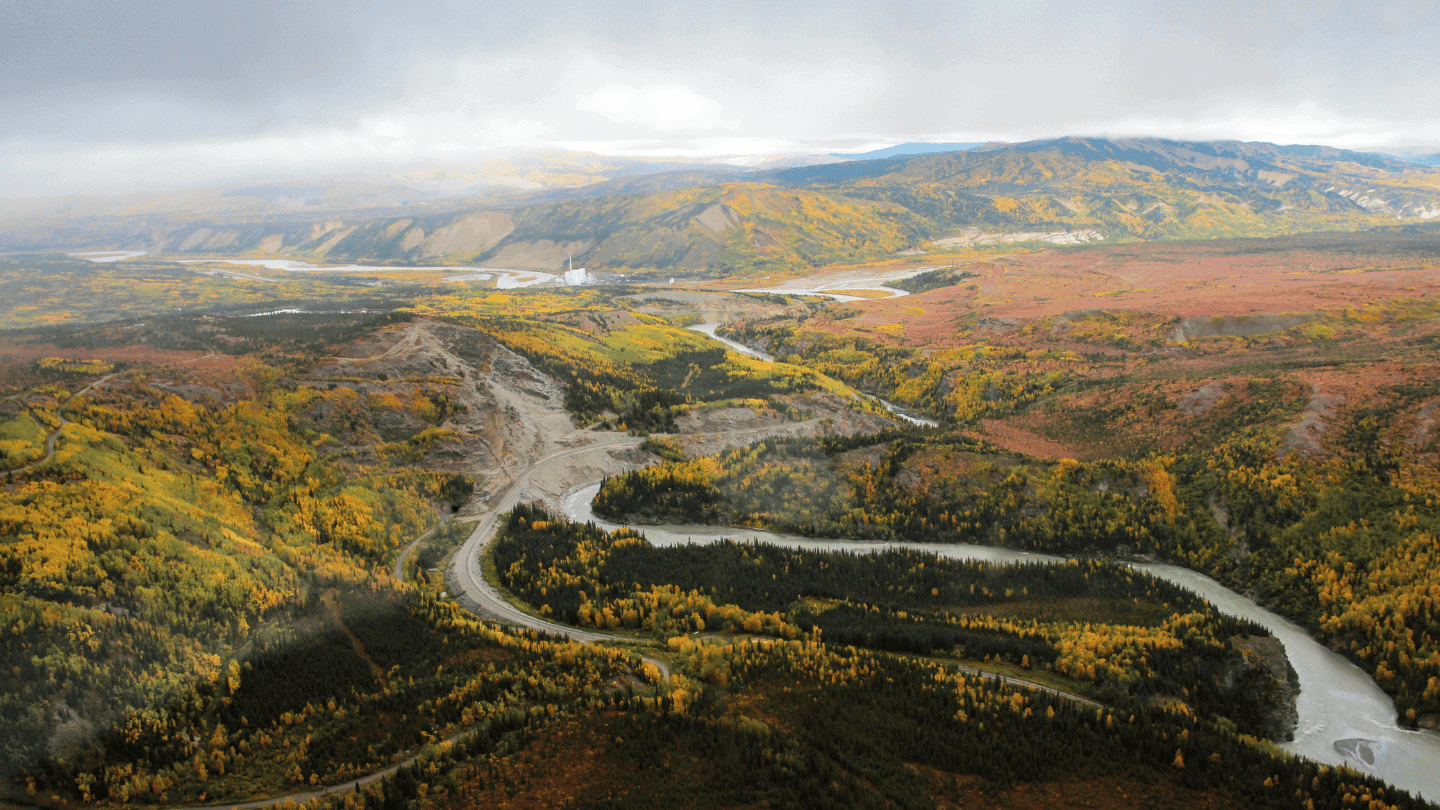 Breathtaking view of Alaska's mountains and winding river in fall colors.