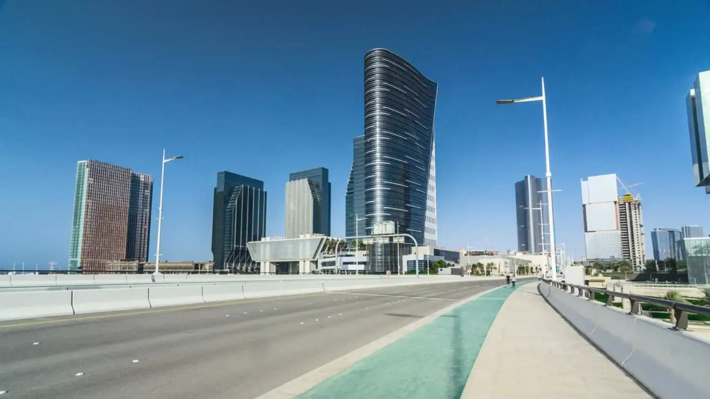 Modern city road and skyline on Al Maryah Island with traffic management and surveillance infrastructure
