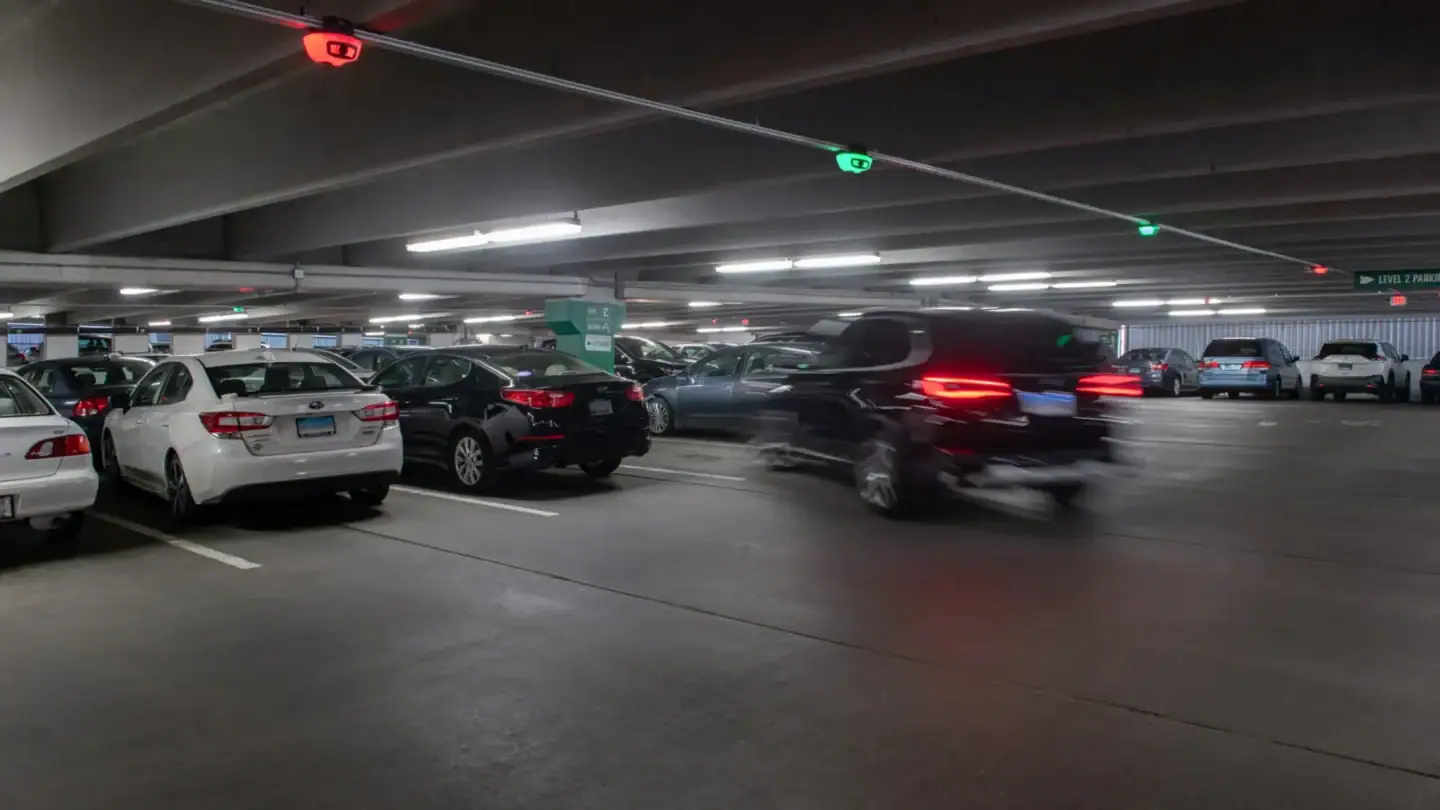 A vehicle parking in a garage in an open space with a green M5 visible
