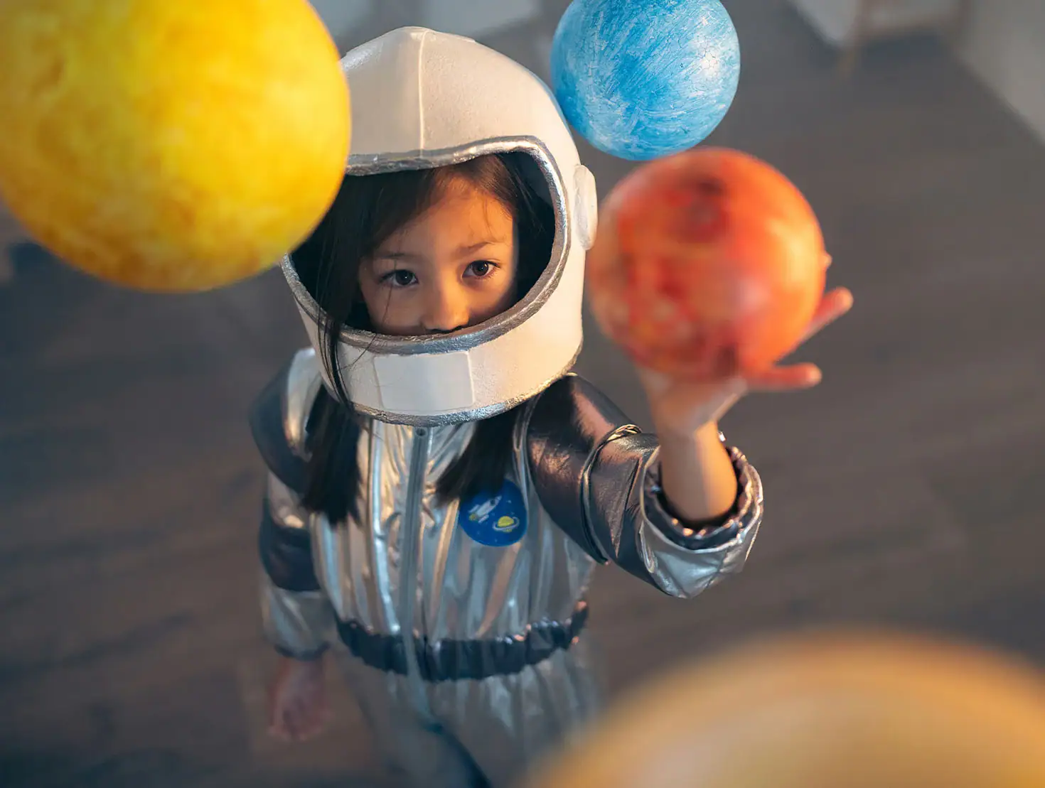 Criança com fato de astronauta a explorar os planetas depois do espetáculo de marionetas.