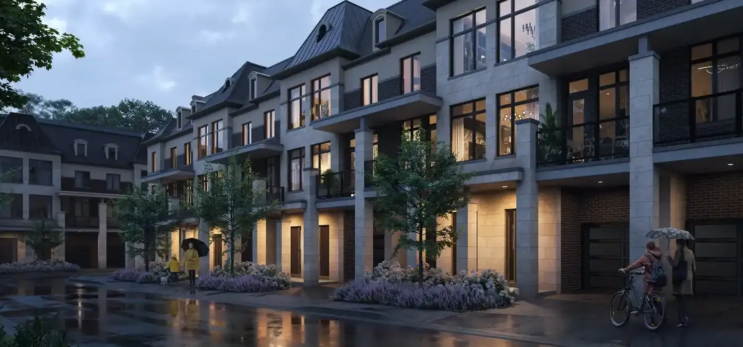 Evening streetscape of Fifth Avenue Homes in Woodbridge, showing modern luxury townhouses with illuminated large windows, stone pillars, and professional landscaping on a rainy night.