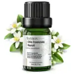 Flacone di olio essenziale di Neroli AMYRON con fiori di zagara e foglie di arancia amara su sfondo chiaro