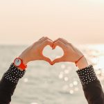 deux mains formant un coeur devant la mer
