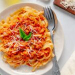 Upclose of a hearty red lentil bolognese sauce on a plate.