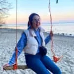 Pracownik biura rachunkowego na plaży, uśmiechnięta kobieta w casualowym ubiorze, fotka promująca usługi rachunkowe od MID GOLF BIURO RACHUNKOWE.