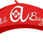 Logo typographique Été à Bayonne en rouge avec lettrage courbe et symbole basque intégré.