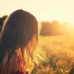 日没の草原を歩く女の子の横顔