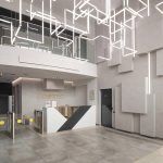 Футуристичное лобби ЖК Loftec между Бауманской и Красносельской с зоной ресепшн, геометрическими панелями с подсветкой и неоновой световой инсталляцией на потолке — фото Кирилла Толль