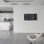 Современная гостиная с ТВ на белой стене, видом на кухонный остров. Район Беговой, Москва.