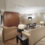 Просторная гостиная с деревянными панелями, креслом Eames и каскадной люстрой в клубном доме Остоженка Парк-Палас.