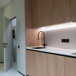 Интерьер малогабаритной кухни из шпона дерева с черным смесителем и подсветкой фартука фотограф Кирилл Толль
