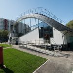Входная группа здания с пандусом и металлическими перилами. Исходная строительная фотография до выравнивания дисторсии и ретуши.