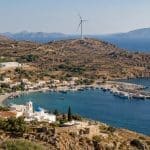 Île grecque avec village côtier, éolienne, panneaux solaires et installation de stockage électrique