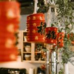 Vibrant red paper lanterns with Chinese script indoors, perfect for festive decorations.