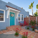 Charming blue bungalow at 3764 Alabama in North Park featuring a bright teal front door, terracotta tile entryway, and a "For Sale" sign in a drought-tolerant front yard.
