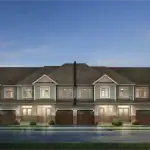 Street-level view of classic townhouses at Mapleview Park with light blue siding, gabled rooflines, decorative white trim, and dark wood-style garage doors.