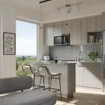 Modern open-concept kitchen and living area interior at Northshore, showcasing a kitchen island with seating, minimalist cabinetry, stainless steel appliances, and large floor-to-ceiling windows with scenic nature views.