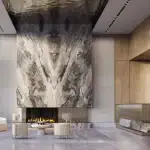 Luxury residential lobby of Kipling Station Condos by CentreCourt featuring a dramatic book-matched marble fireplace wall, modern lounge seating, a gold-accented concierge desk, and high-gloss reflective ceilings.