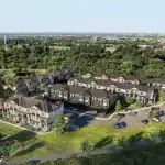 Brooklin Towns - Urban Towns Aerial Aerial view of the Brooklin Towns residential community showing multiple blocks of modern townhomes surrounded by lush green forests, a community park, and a playground.