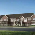 Architectural rendering of traditional two-storey townhomes in the Seaton Whitevale community, featuring red brick exteriors, white window trim, peaked gables, covered front porches, and built-in garages under a clear blue sky.