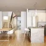 Bright open-concept kitchen and dining area in a Whitby Meadows home, featuring white cabinetry, a marble-patterned island, stainless steel appliances, and light hardwood flooring.
