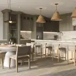 Modern open-concept kitchen interior at Caledon Club, showcasing olive green cabinetry, a large white marble island with seating, woven pendant lights, and an adjacent round dining table.