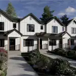 Modern white farmhouse-style townhomes with black trim and gabled roofs in the Cy Becker neighborhood, featuring concrete walkways and landscaped front yards.