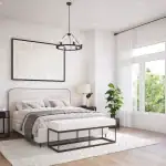 Spacious, sun-lit primary bedroom at Townhomes of Little Rouge with neutral decor, a large upholstered headboard, a black wheel-style chandelier, and wide-plank hardwood flooring.