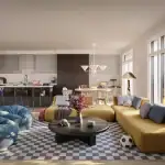 Bright and playful living area in a Wild Indigo detached home featuring a yellow sectional sofa, blue bean bags, a checkered rug, and a modern kitchen in the background.