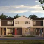 East Hills Crossing - Rear Lane Towns Street-level view of East Hills Crossing Rear Lane Townhomes featuring colorful entry doors, large windows, and landscaped front yards in a walkable community setting.