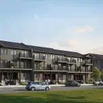 Modern stacked urban townhouses at Cadence showing multi-level units with spacious balconies, dark grey siding, and brick accents overlooking a paved parking area.