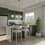 Modern kitchen interior at Aura Lakeview Village townhomes featuring forest green cabinetry, gold hardware, a white quartz waterfall island with bar stools, and stainless steel appliances.