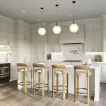 Modern open-concept kitchen interior at The Valley Woodbridge featuring white cabinetry, a large marble island with wood stools, and globe pendant lighting.