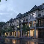 Fifth Avenue Homes Woodbridge - 1 Evening streetscape of Fifth Avenue Homes in Woodbridge, showing modern luxury townhouses with illuminated large windows, stone pillars, and professional landscaping on a rainy night.