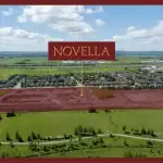 Aerial view of the Novella Estates construction site in Meadowvale, showing land clearing and infrastructure development for a new residential community adjacent to green space.