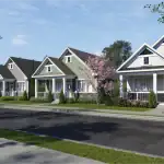 A row of modern craftsman-style bungalow homes in the Black Creek community, featuring various siding colors including green, grey, and white with stone accents, manicured lawns, and blooming trees along a quiet paved street.