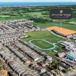 Aerial view of the On The Ridge community in Stoney Creek, showing the development site highlighted in orange near Upper Centennial Parkway and Highland Road West, adjacent to a local school and athletic track.