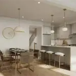 Heartwood Village - Kitchen Luxury kitchen and dining area at Heartwood Village with white cabinetry, a large island with gold-accented stools, contemporary pendant lighting, and hardwood flooring.